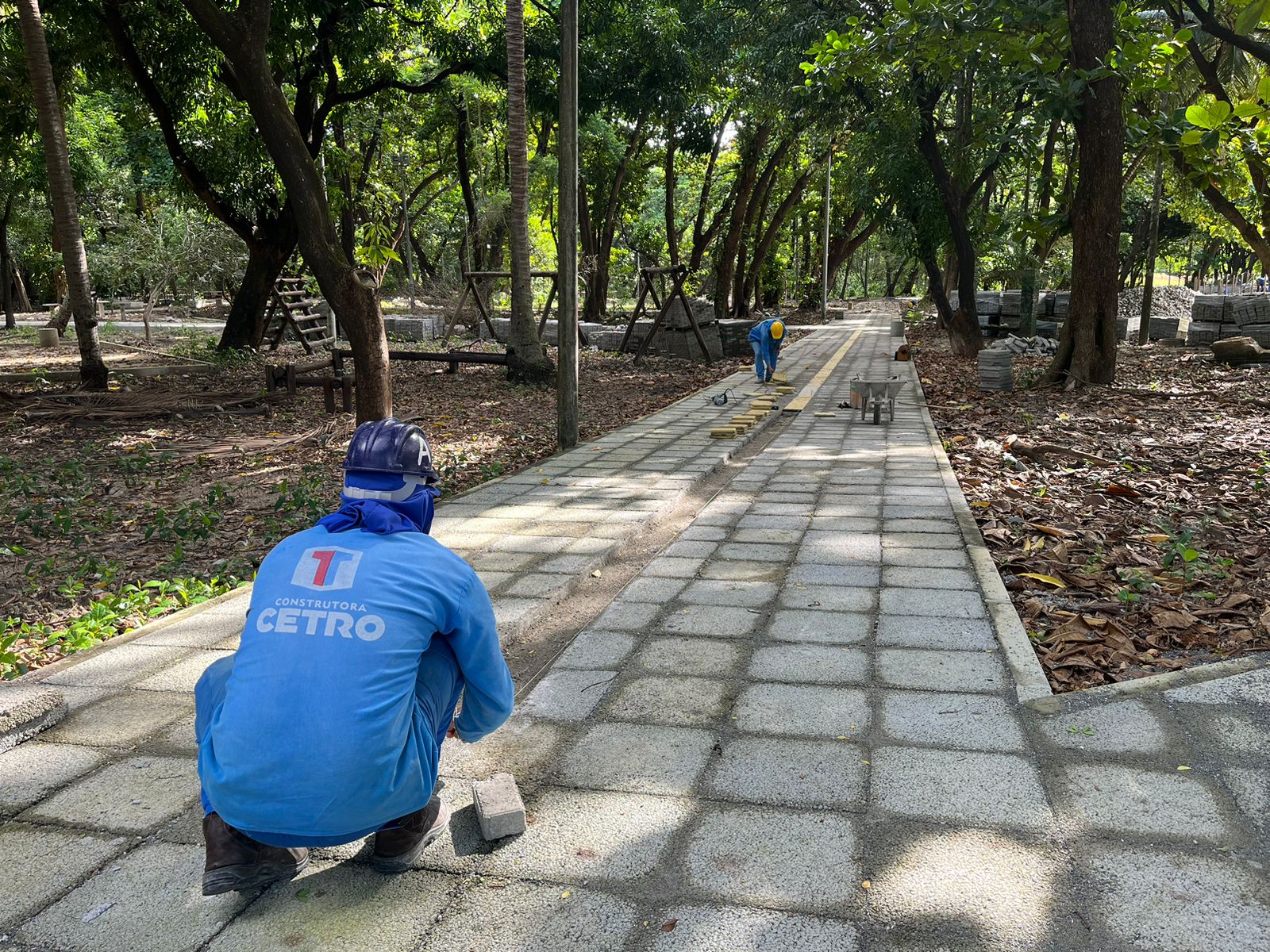 homens trabalhando no piso intertravado do parque